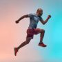 New champion. Full length of young african man in sports clothing jumping against colorful background. Sport concept. Motivation. Healthy lifestyle